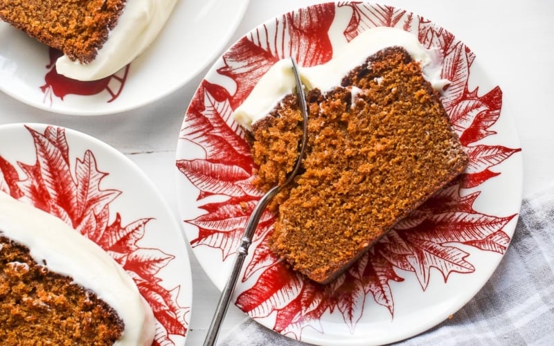 moist gingerbread loaf cake with cream cheese frosting on a plate with fork
