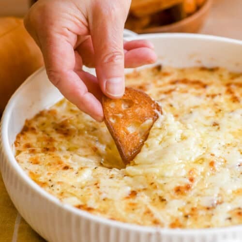 Dipping toasted bread into a baked Vidalia onion dip.