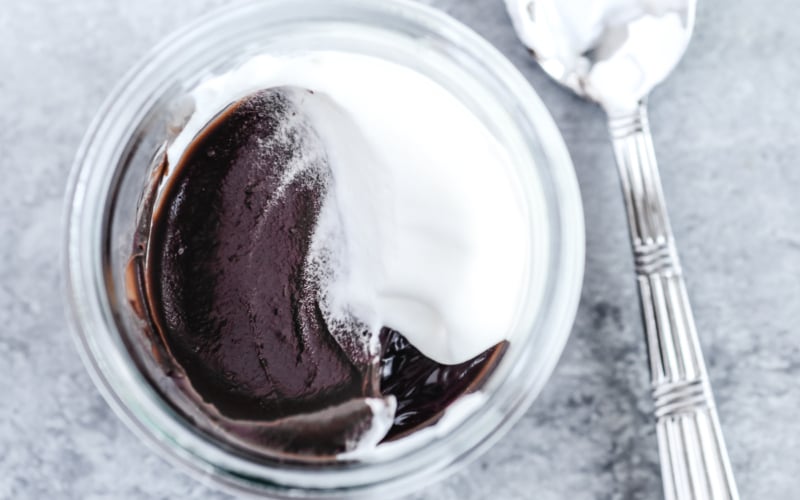 chocolate pudding in a cup with whipped cream and spoon