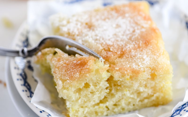 taking a bite of a slice of lemon crunch cake