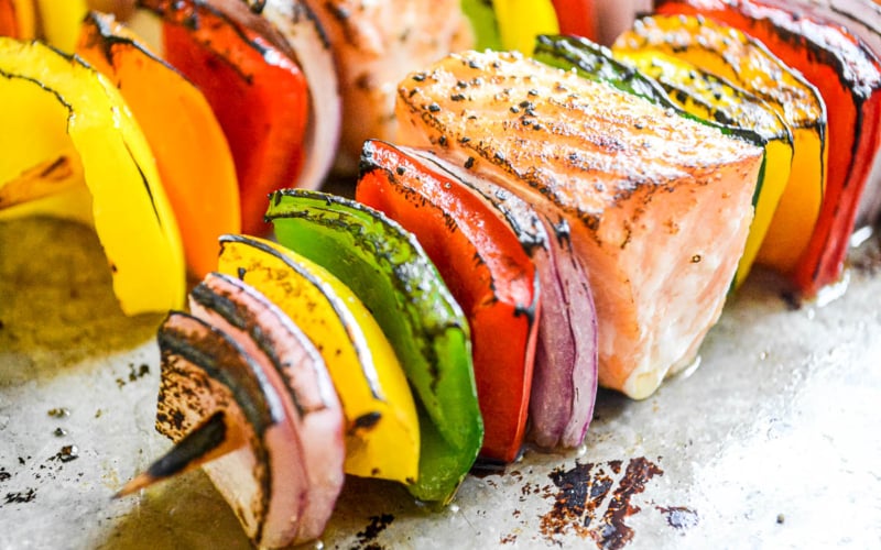 Rainbow salmon skewers, charred.