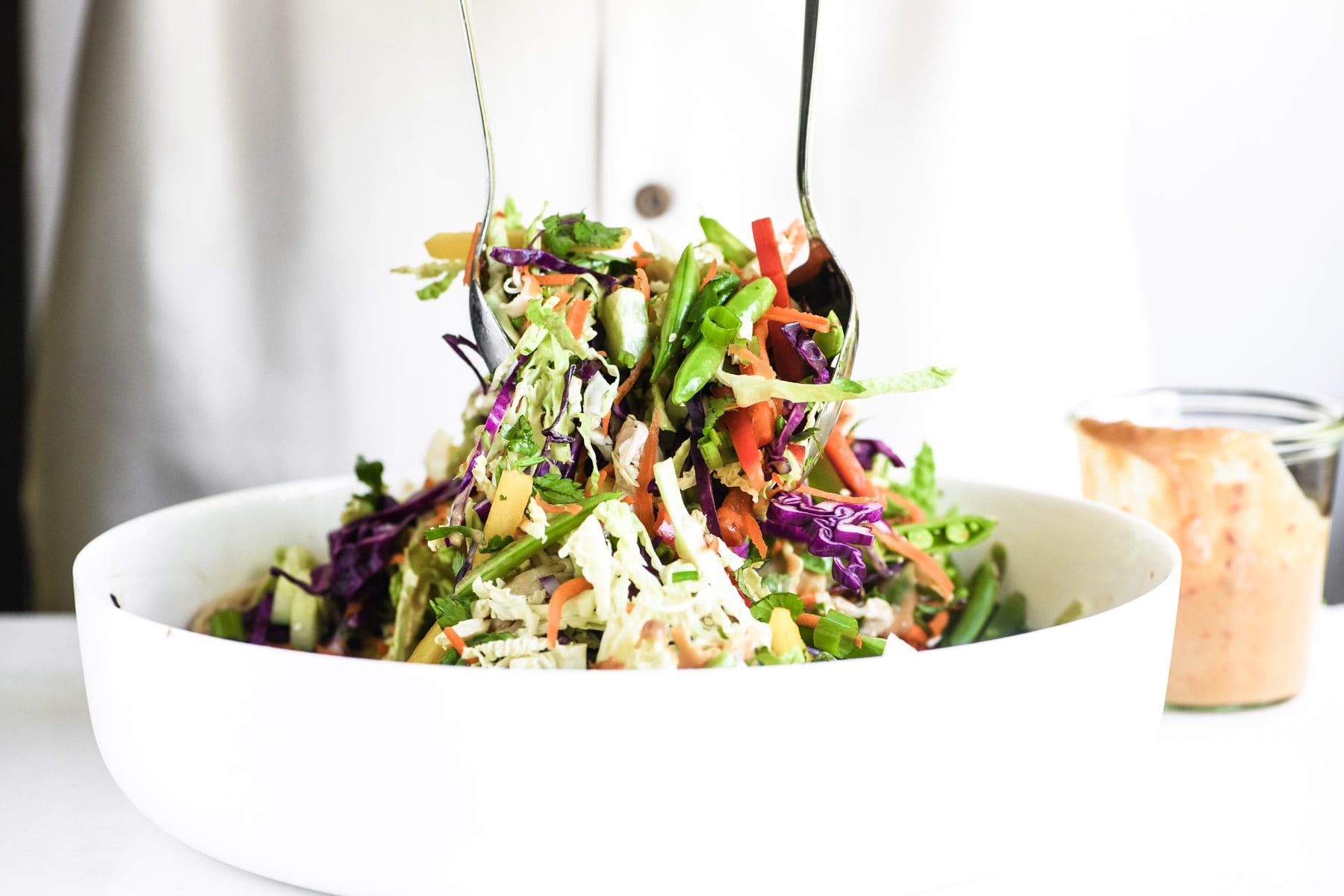 tossing Thai chicken salad