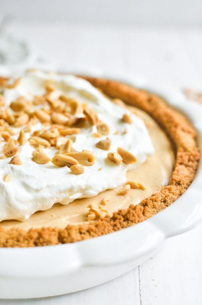 peanut butter pie with crumb crust in a white pie dish.