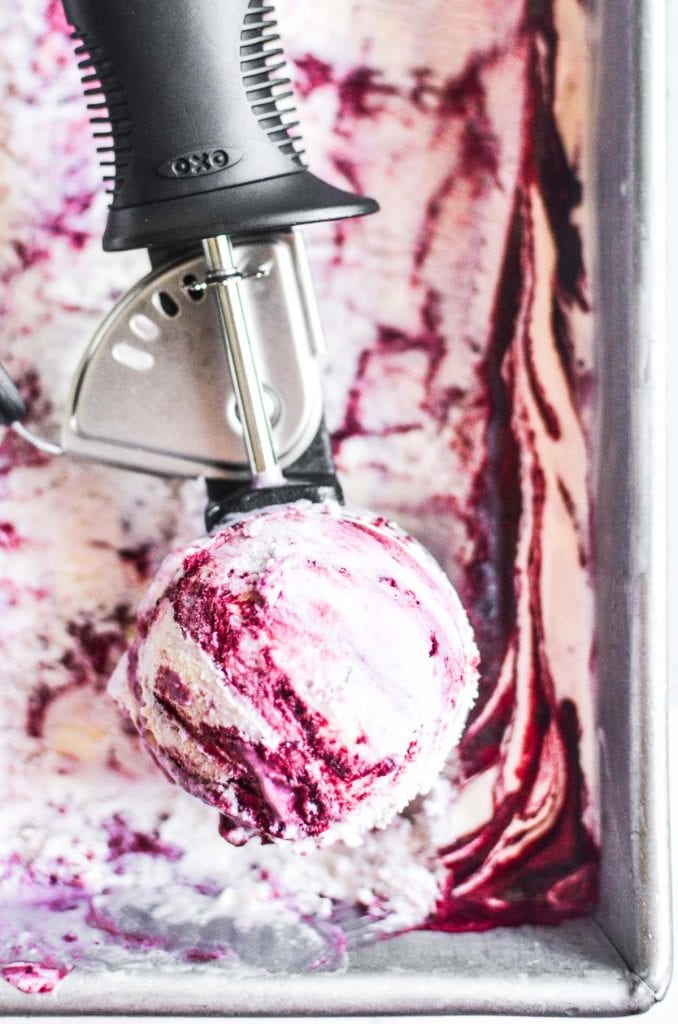 black raspberry ice cream in a pan, with scoop