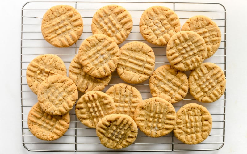 peanut butter cookies, piled on a baking rack
