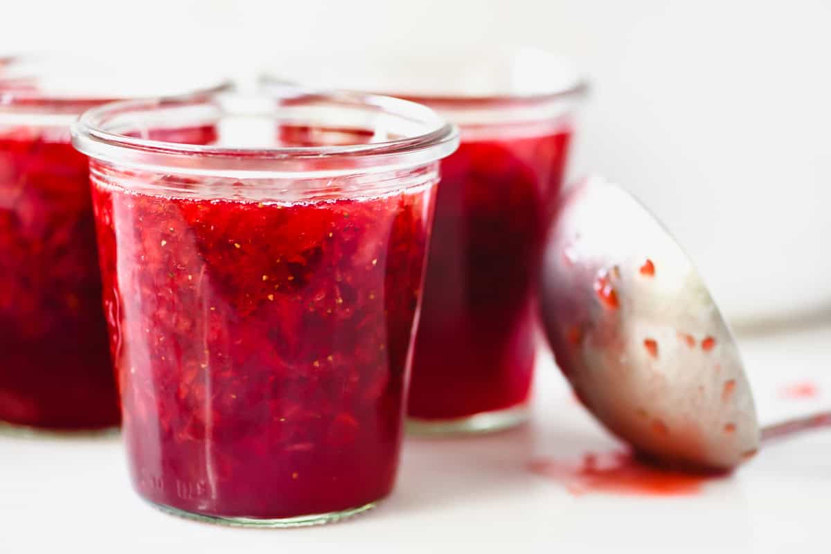 Jars of homemade Sure-Jell strawberry jam, ready to can.