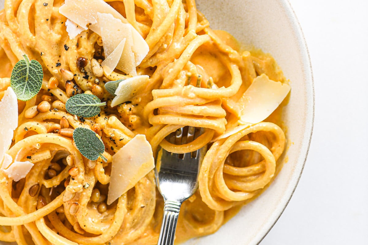 a bowl of pumpkin Alfredo pasta with sage and pine nuts
