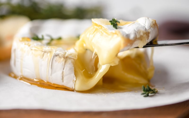 taking a wedge of gooey baked Brie