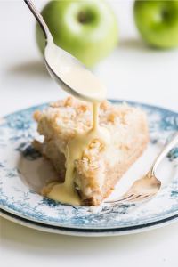 Spooning traditional custard sauce on Irish apple cake