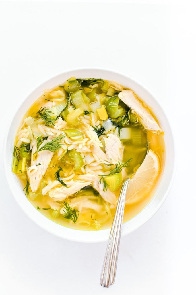 lemony chicken soup with orzo in a white bowl