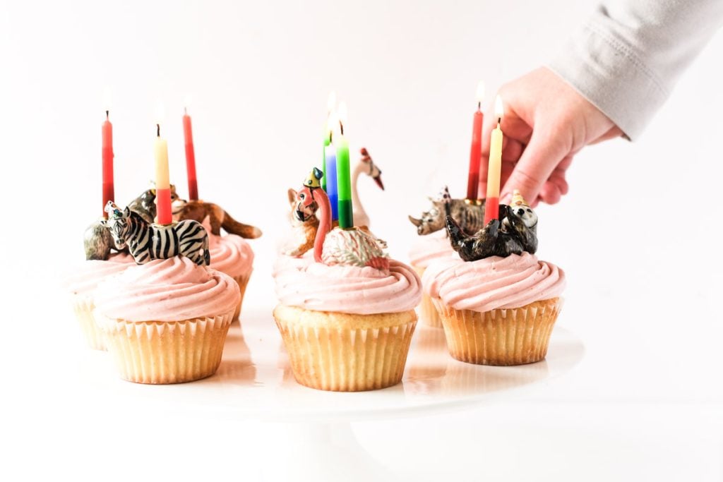 placing candles on strawberry cupcakes for perfect little individual desserts.