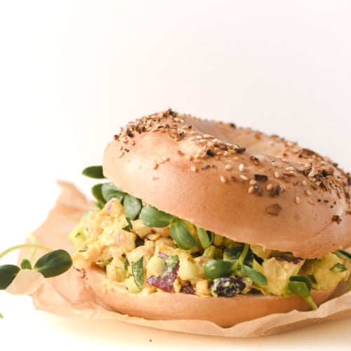 a curried chickpea salad sandwich on a bagel