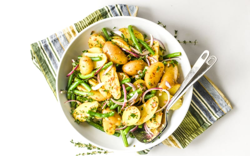 French Potato Salad in a bowl with striped napkin