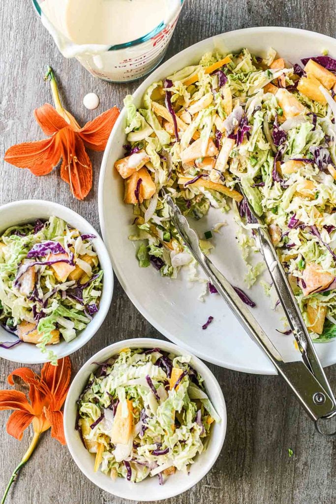 coconut pineapple slaw in a bowl with lilies