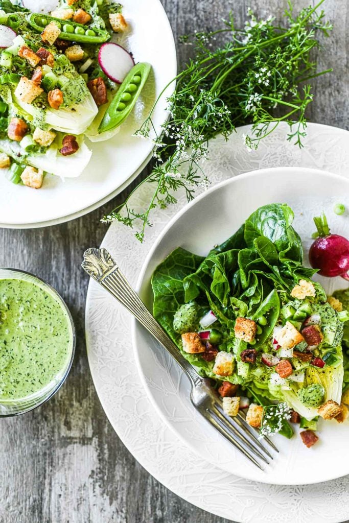 Green goddess salad on white plates