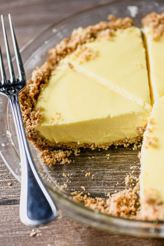 lemon butter pie in a glass pie dish with fork
