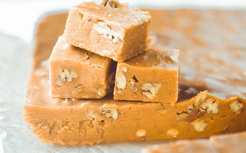pumpkin fudge, stacked on parchment paper.