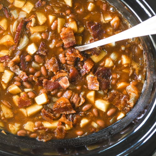 apple butter baked beans with bacon in a slow cooker.