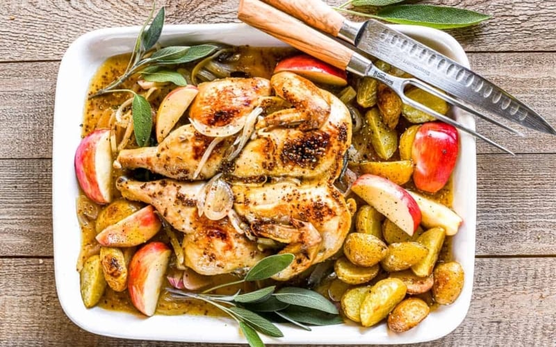 Cider braised chicken with sage, on a white platter.