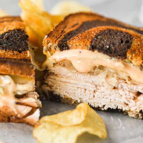 Sheet pan turkey Reuben sandwich, sliced in half.