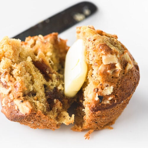 A freshly made date nut muffins split open with butter.