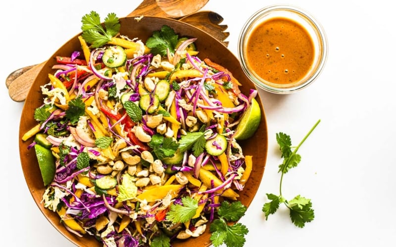 Thai mango salad in a wooden bowl.