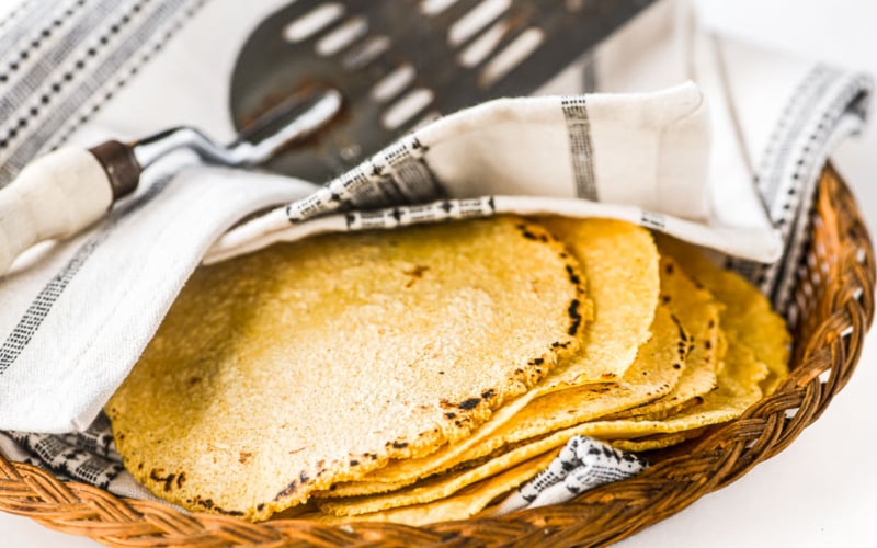 stacked tortillas under a towel.