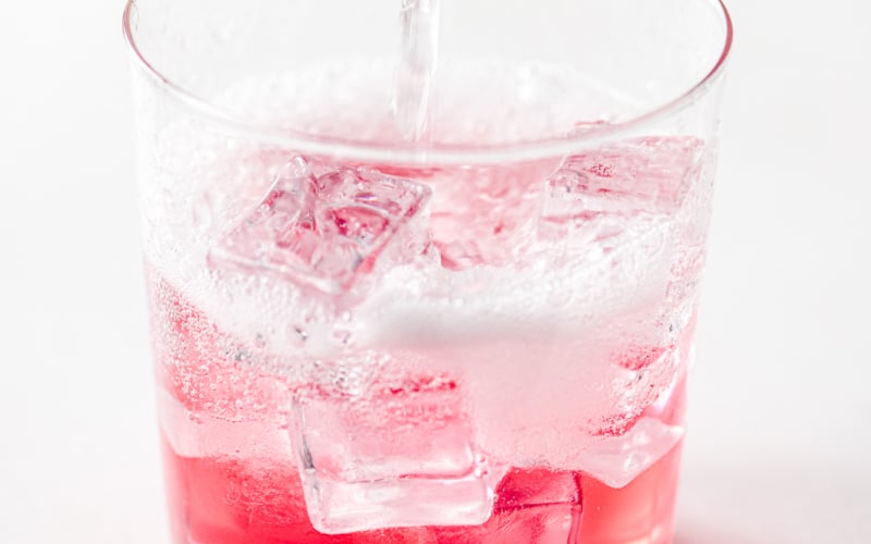 pretty pink rhubarb soda in a glass with ice.