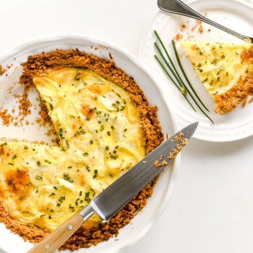 Vidalia Ritz Pie in a white pie plate with a piece on a serving plate.