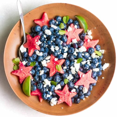 red white and blueberry fruit salad in a wooden bowl.