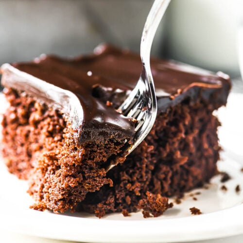 Taking a bite of a chocolate sheet cake with a fork.