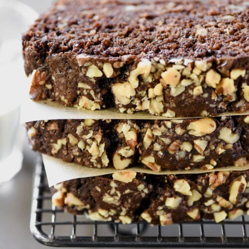 A stack of Brownie Bread slices, with a small glass of milk.