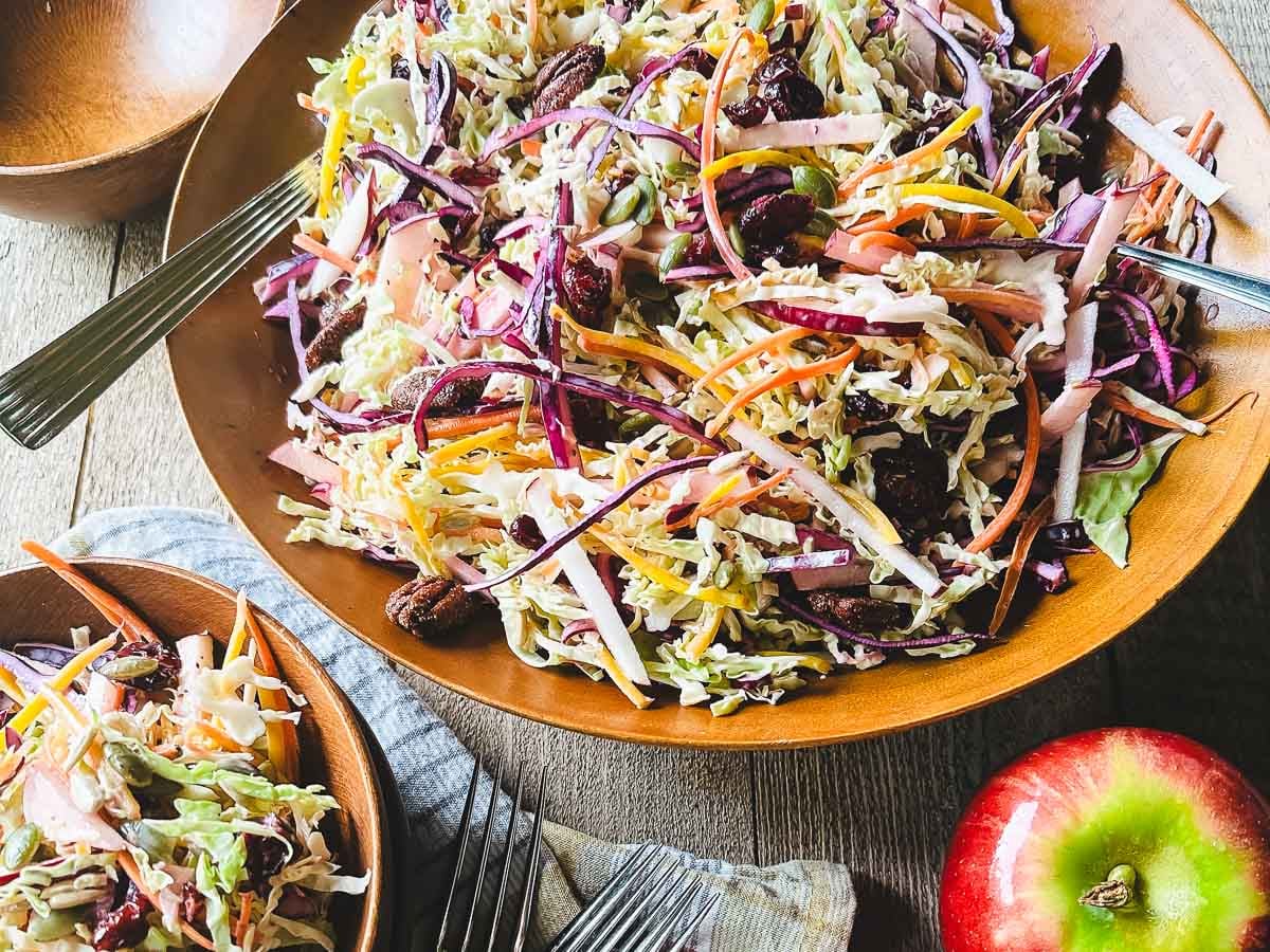 fall apple slaw in a wooden bowl with apples.