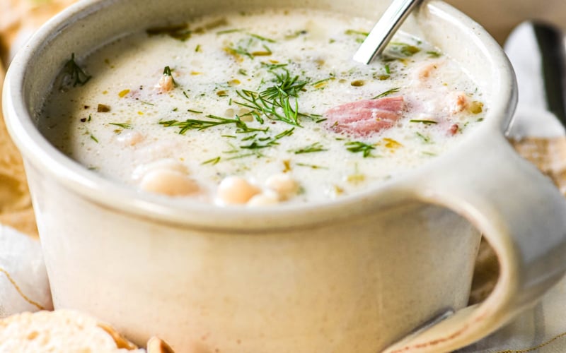Romanian Bacon Soup in a white stoneware mug.