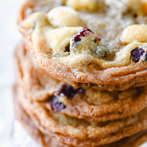 A stack of thin and crispy white chocolate cranberry cookies