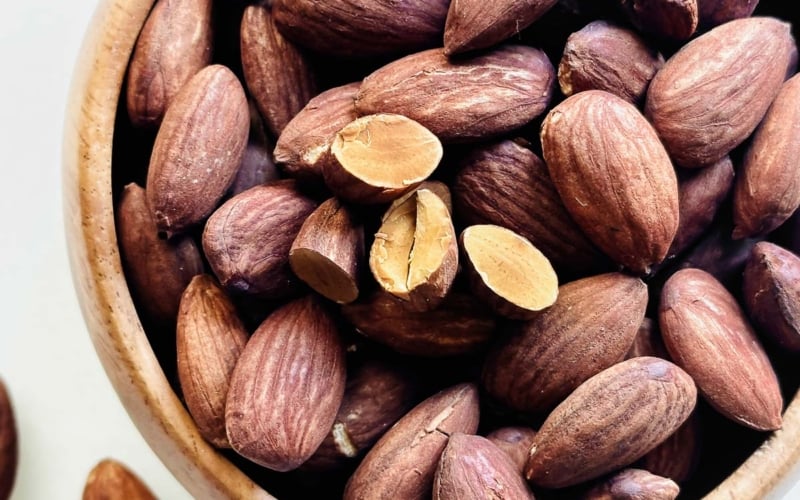 Dark roasted almonds, in a bowl.