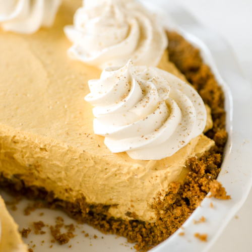 Pumpkin mousse pie with gingersnap crust and whipped cream topping.