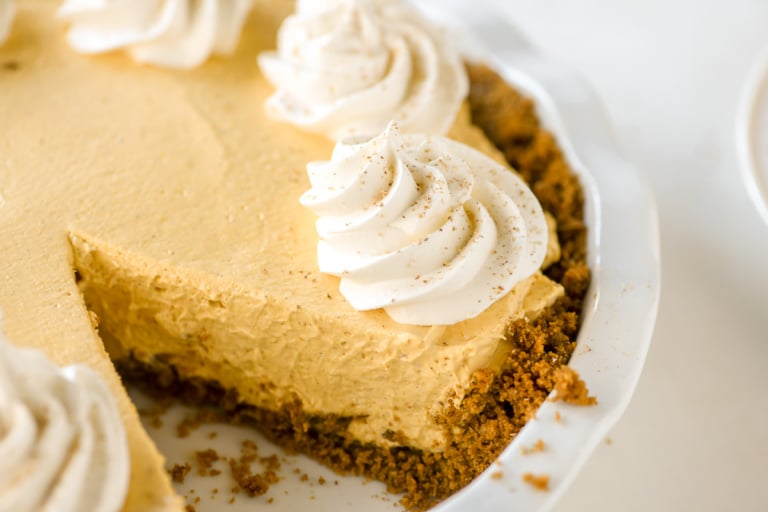 Pumpkin mousse pie with gingersnap crust and whipped cream topping.