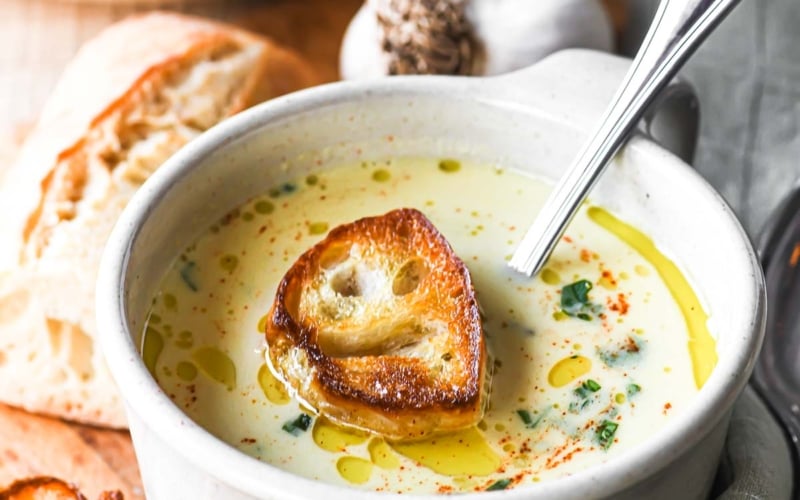 Country French Garlic Soup in a mug with croutons.