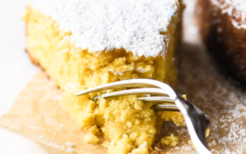 Taking a bite of Meyer lemon cake topped with powdered sugar.