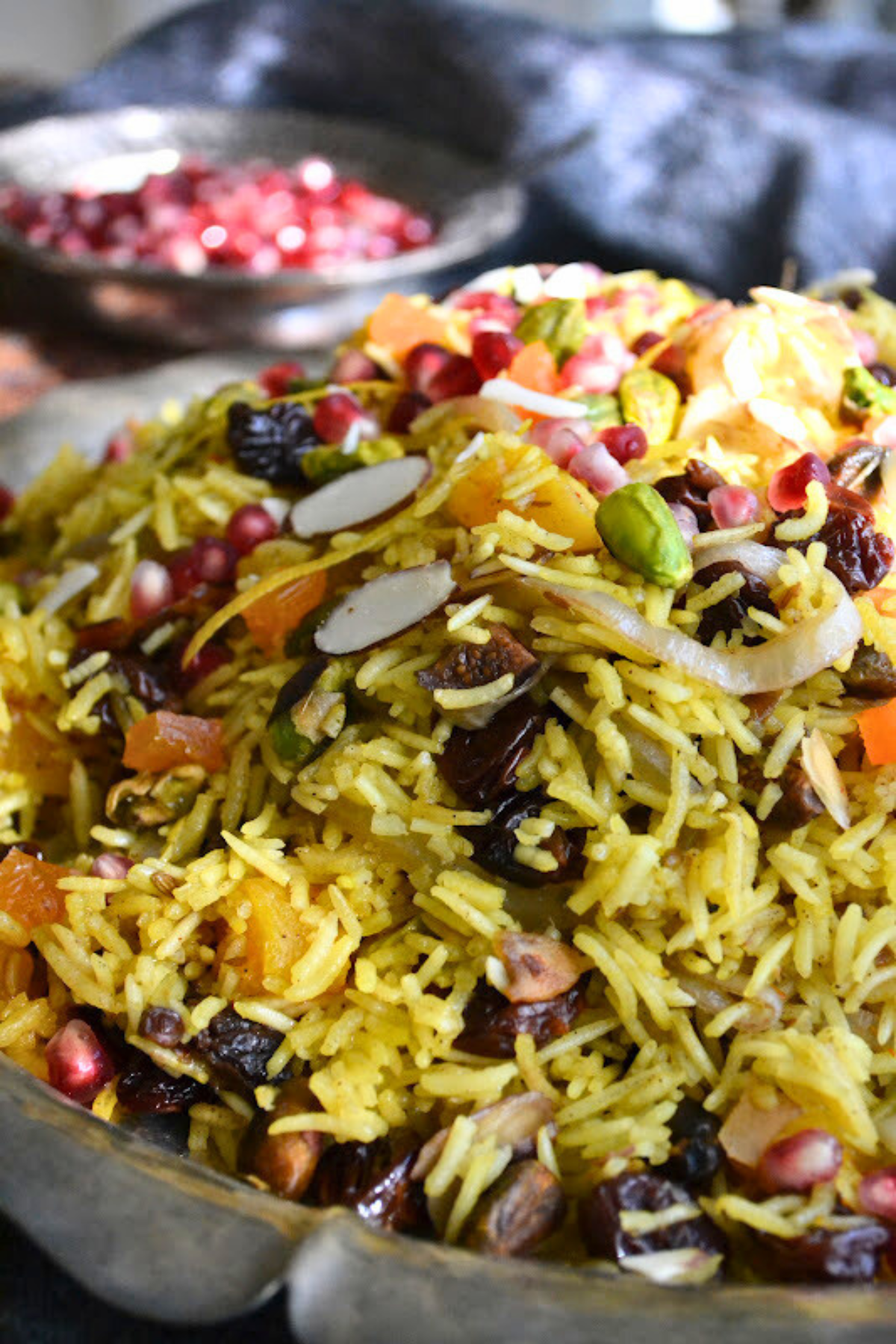 Persian Jeweled Rice is a gluten free, vegan rice pilaf topped with colorful gem-like fruits and nuts ~ this popular wedding dish is gorgeous! #easy #recipe #authentic #vegan #glutenfree #iranian #traditional #wedding #middleeastern #basmati #saffron #Christmas #passover #Easter Thanksgiving A mound of Persian Jeweled Rice.