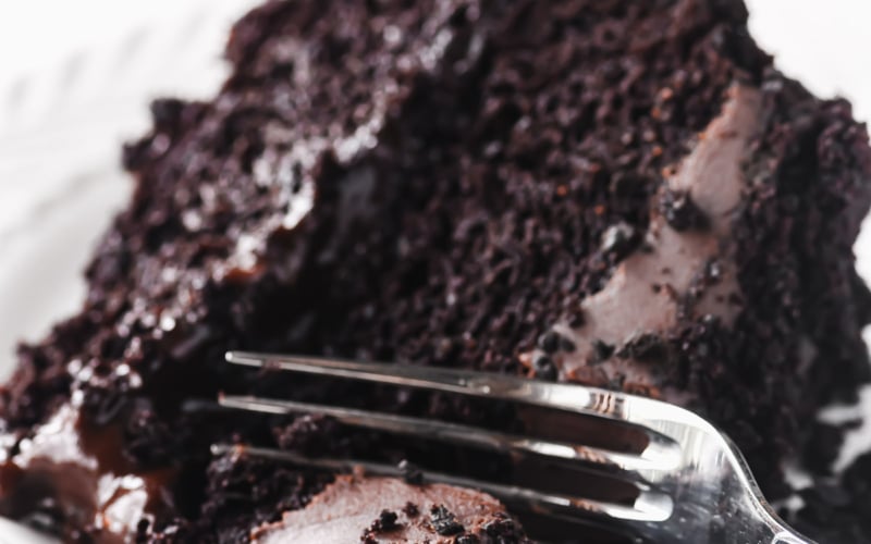 Taking a bite of chocolate blackout cake with a fork.