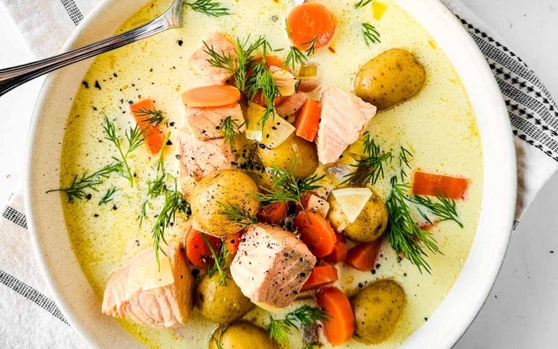 creamy salmon soup with lemon in a bowl with spoon.
