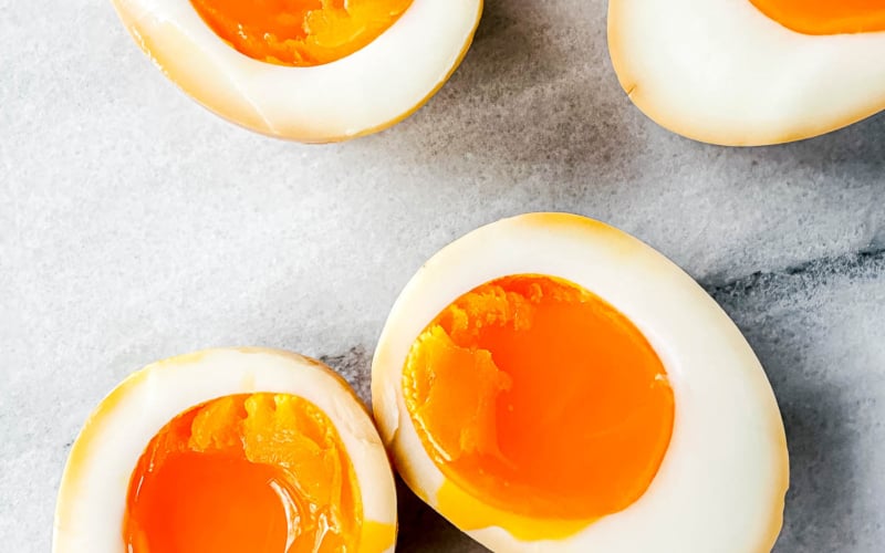 Japanese ramen eggs, sliced open to reveal soft yolks.
