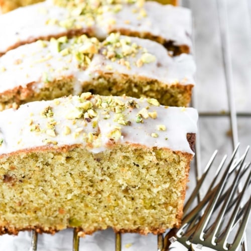 Cardamom pistachio pound cake, sliced with forks.