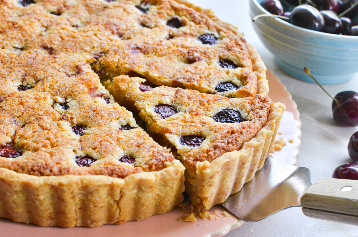 Taking a slice of a cherry almond tart.