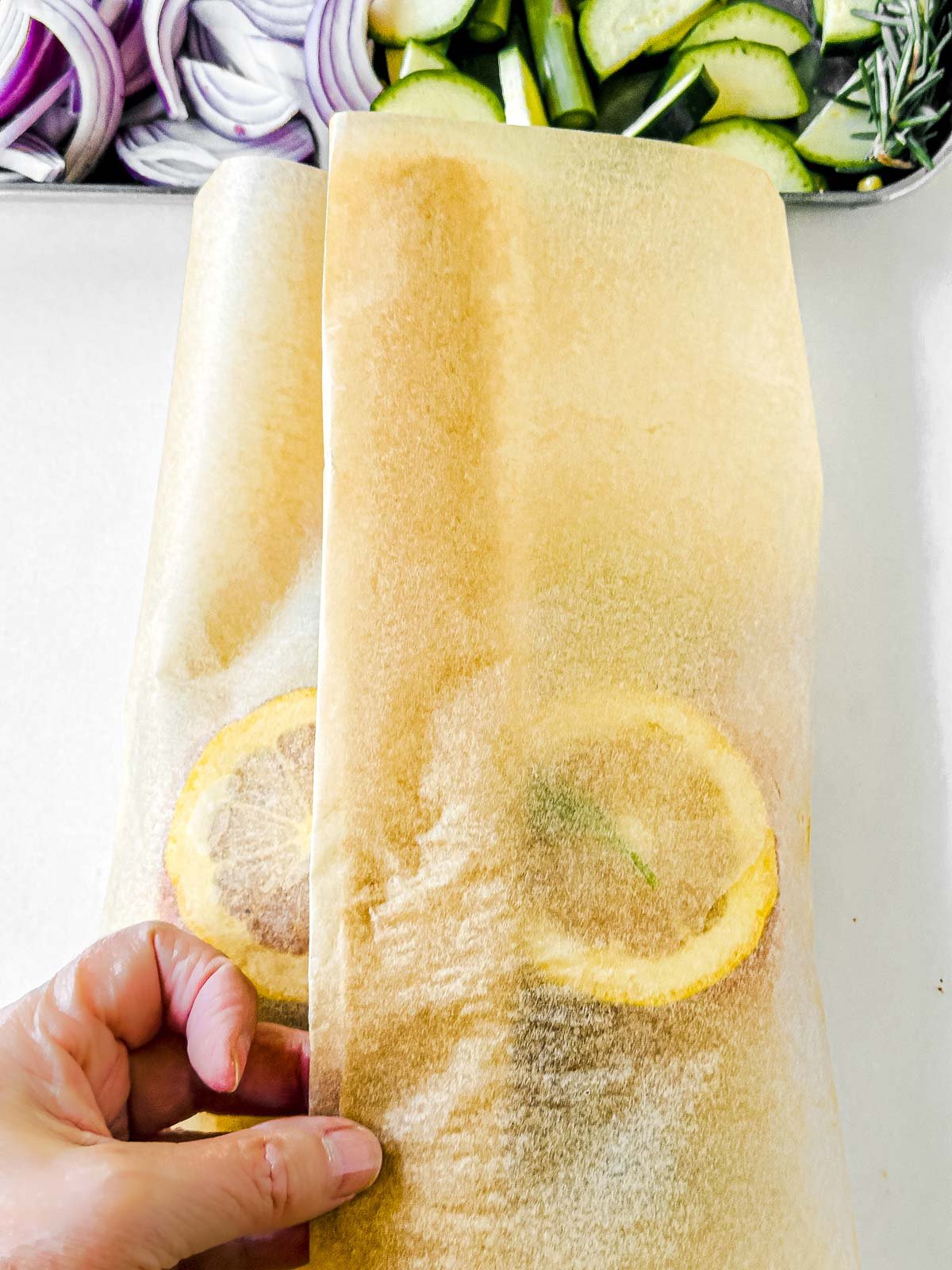 Wrapping a salmon packet in parchment paper.