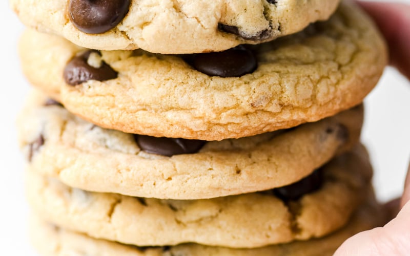 hand holding a stack of soft batch chocolate chip cookies.