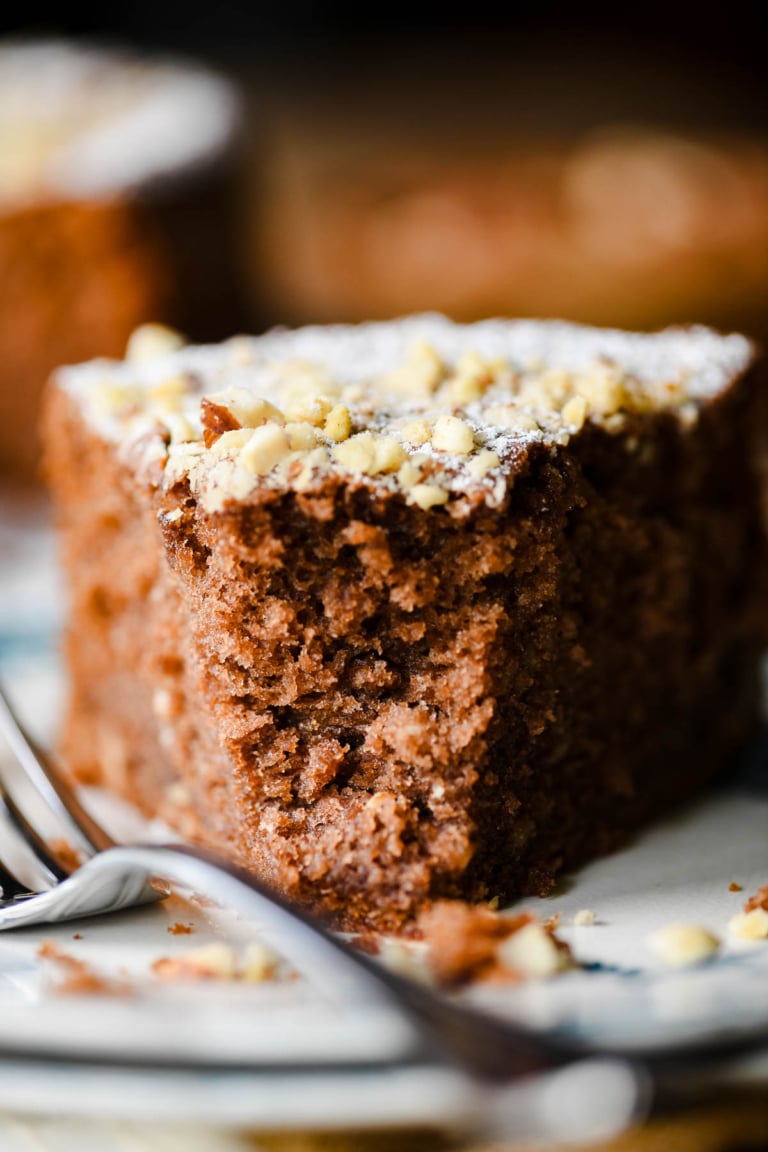 Closeup of slice of mocha hazelnut cake with bite taken.