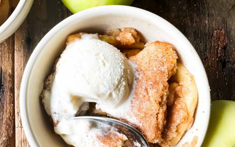 cider doughnut apple cobbler in a bowl with ice cream.